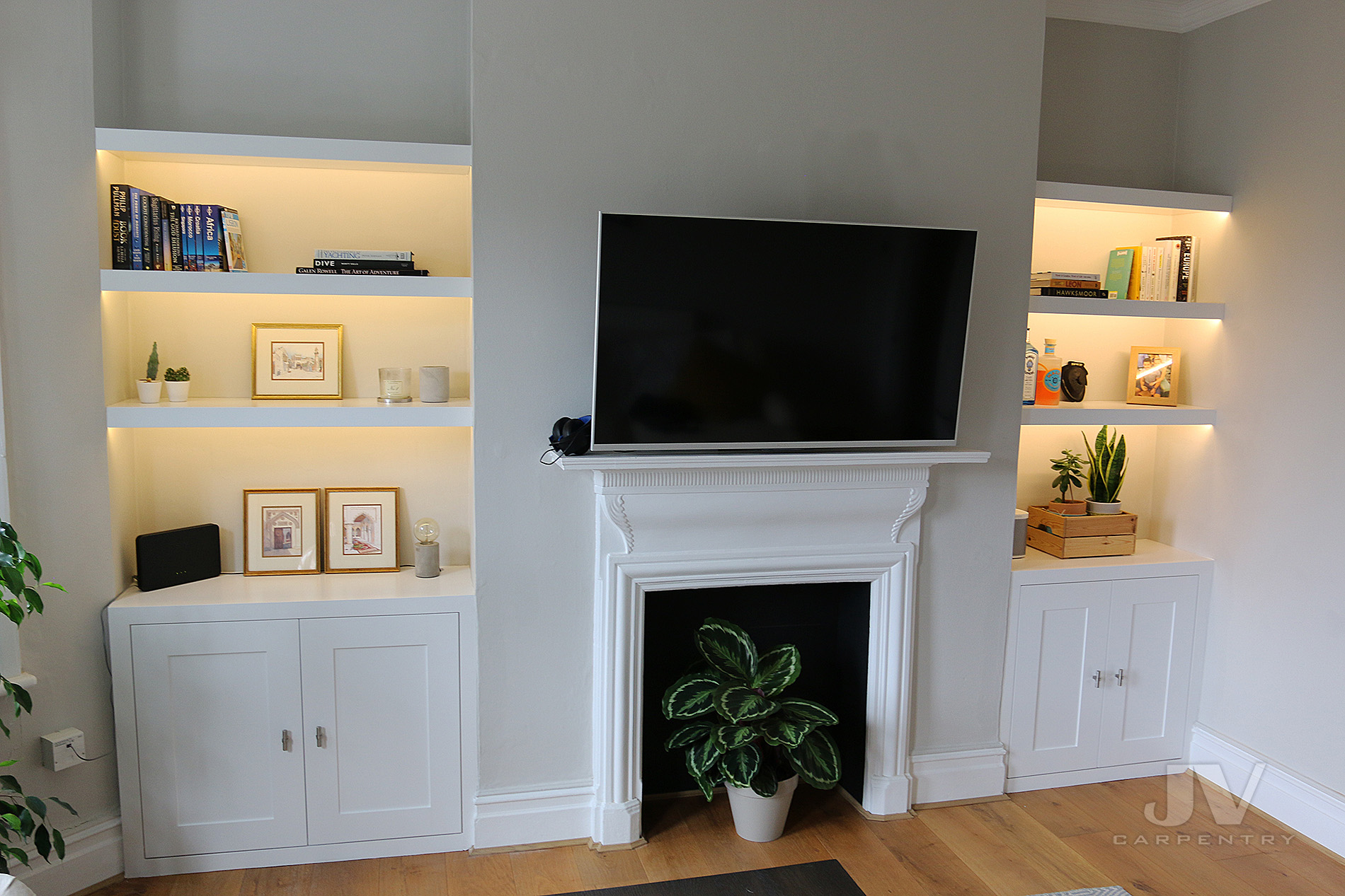 alcove bookshelves with light and cabinet either side of the chimney breast