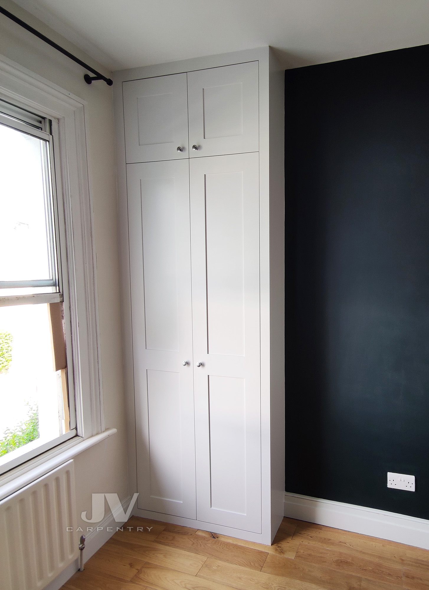 fitted wardrobe in an alcove by the window