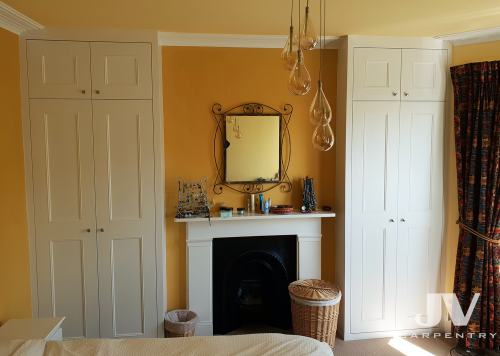 Hand crafted alcove wardrobes either side of the chimney