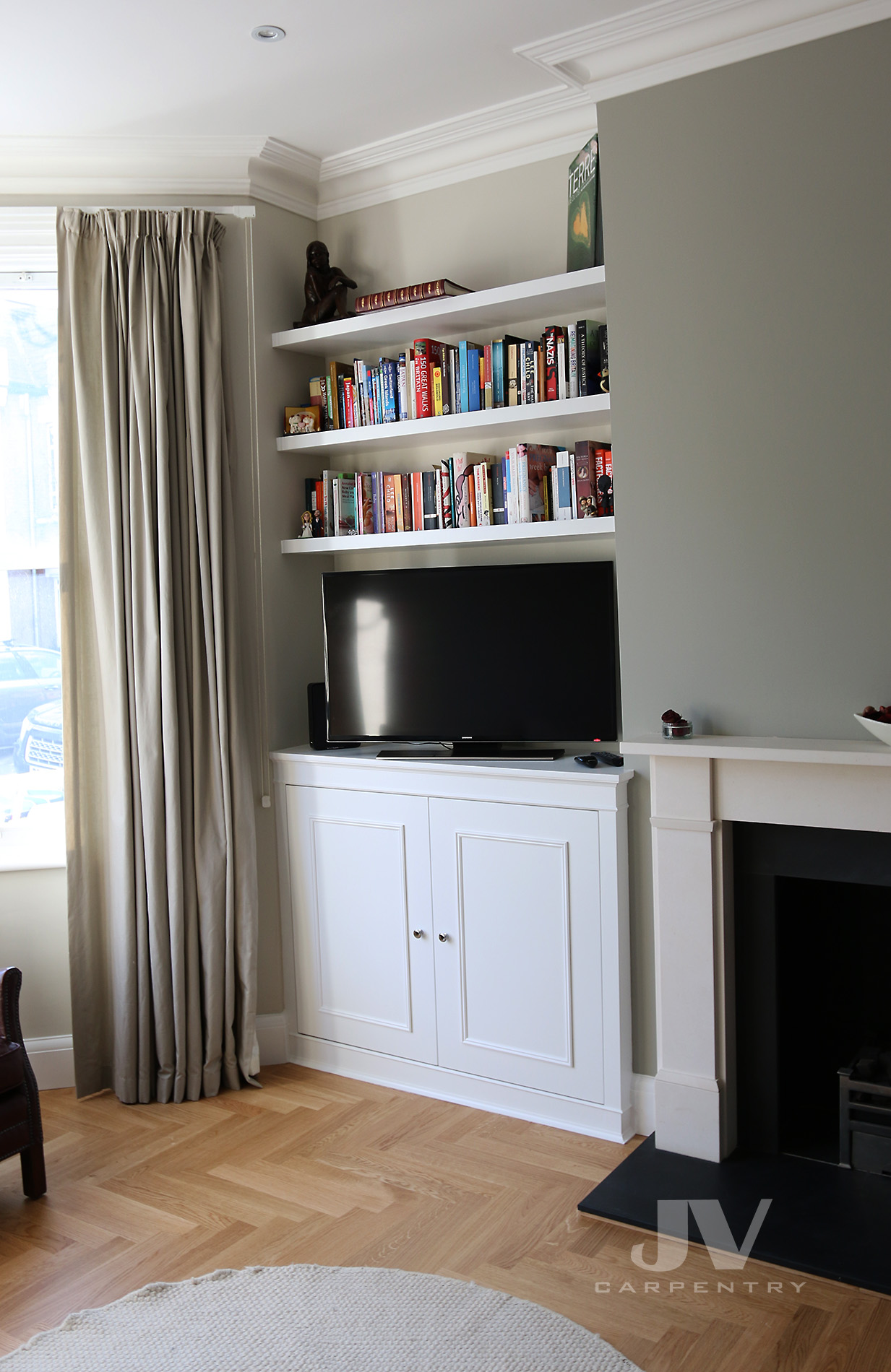 alcove fitted cabinet with tv and shelves above