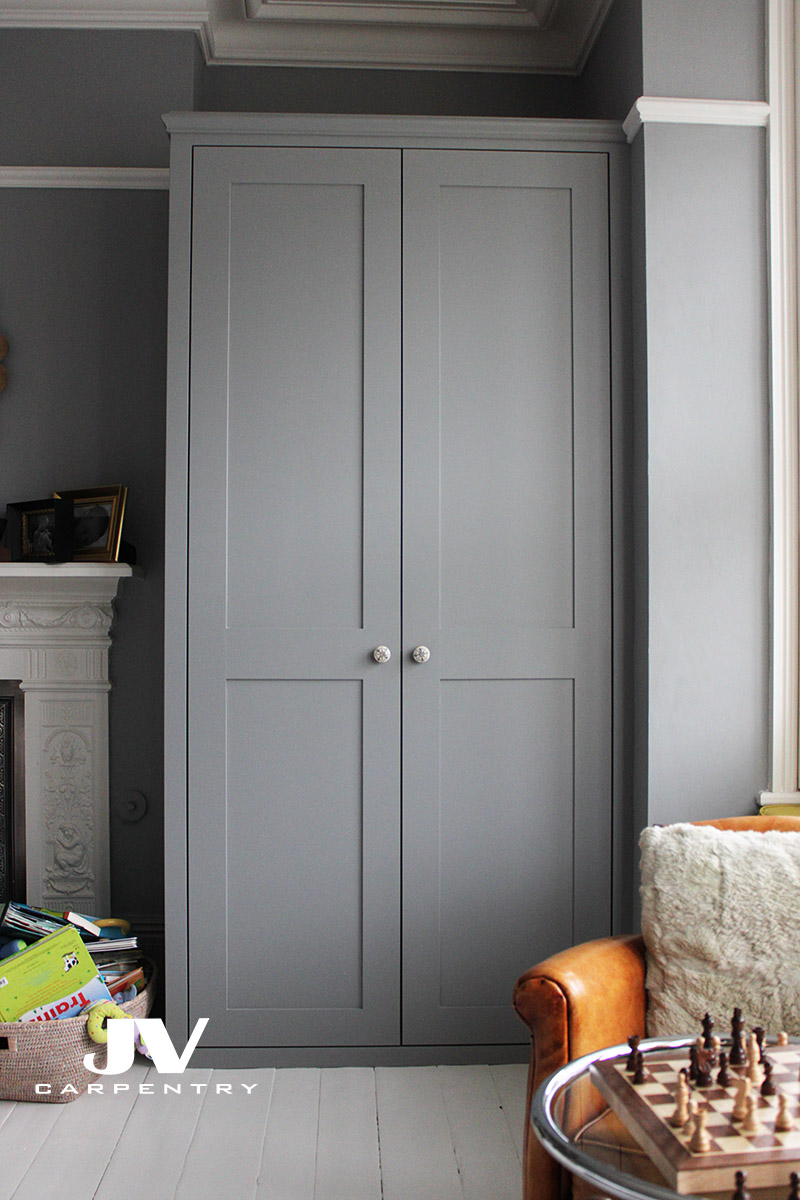 Grey alcove fitted wardrobe made with the same picture raila over the top and two shaker doors. This wardrobe made with drawers, hanging rail and shelves inside