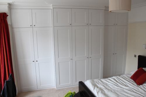 A full wall length bespoke wardrobe fitted around chimney breast